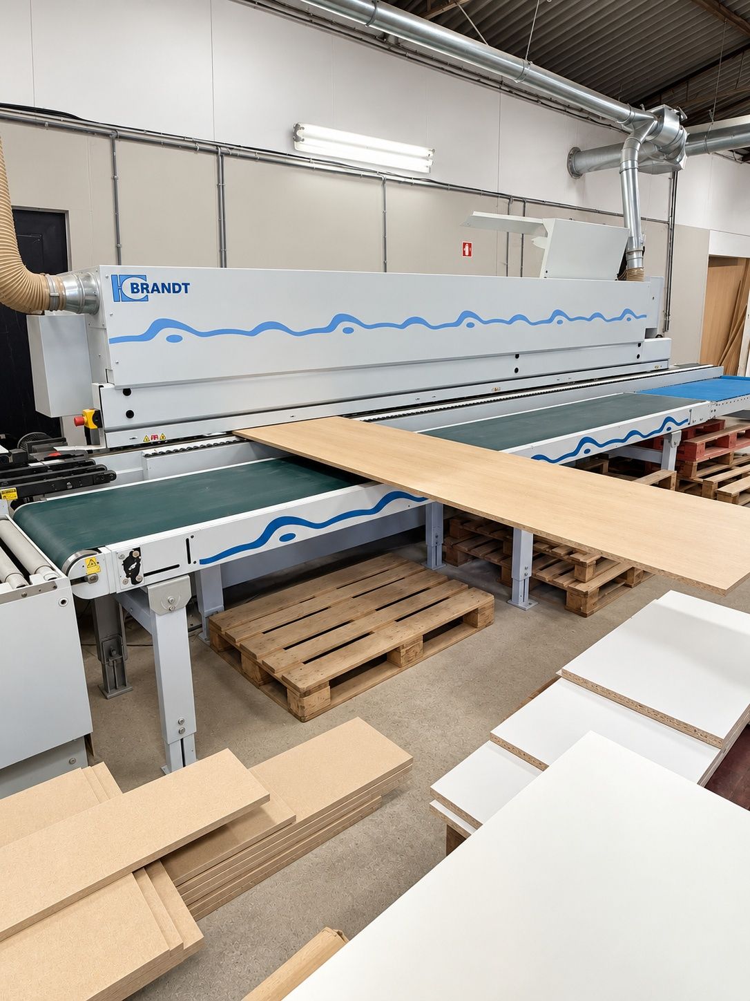 Plaqueuse de chants et panneaux en cours de finition dans un atelier