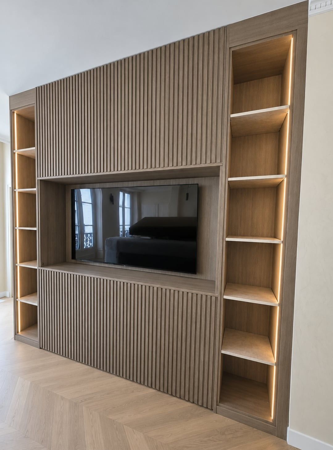 Meuble TV à façade rainurée, encadré de niches ouvertes éclairées par un ruban LED