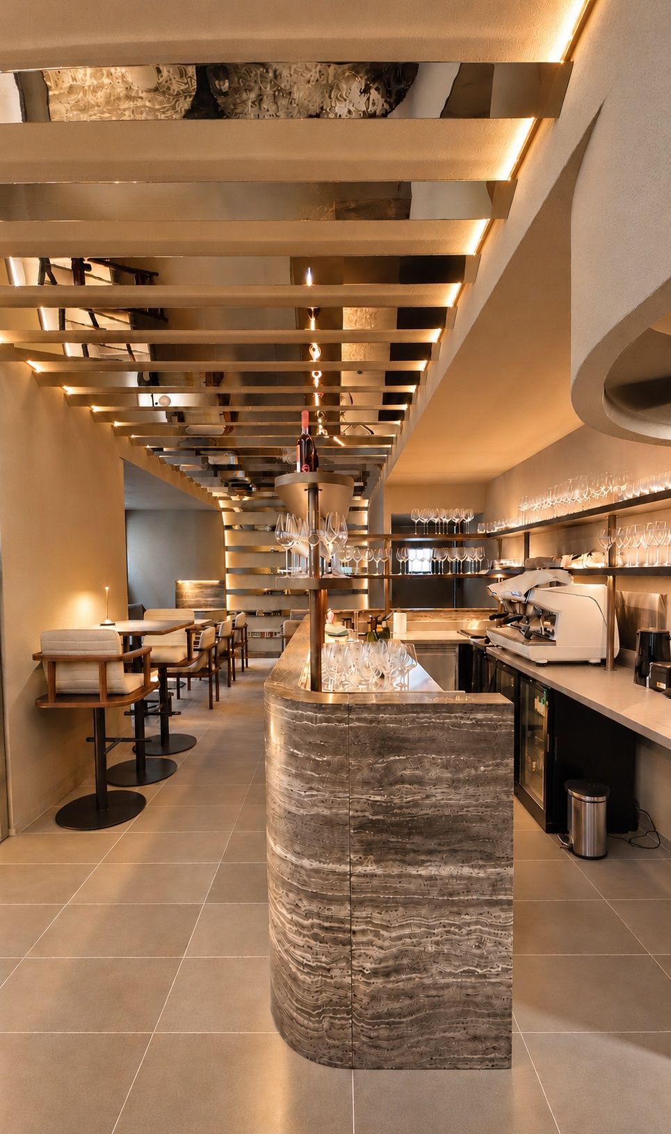 Bar en pierre veinée sous un plafond à lames de bois, dans un restaurant